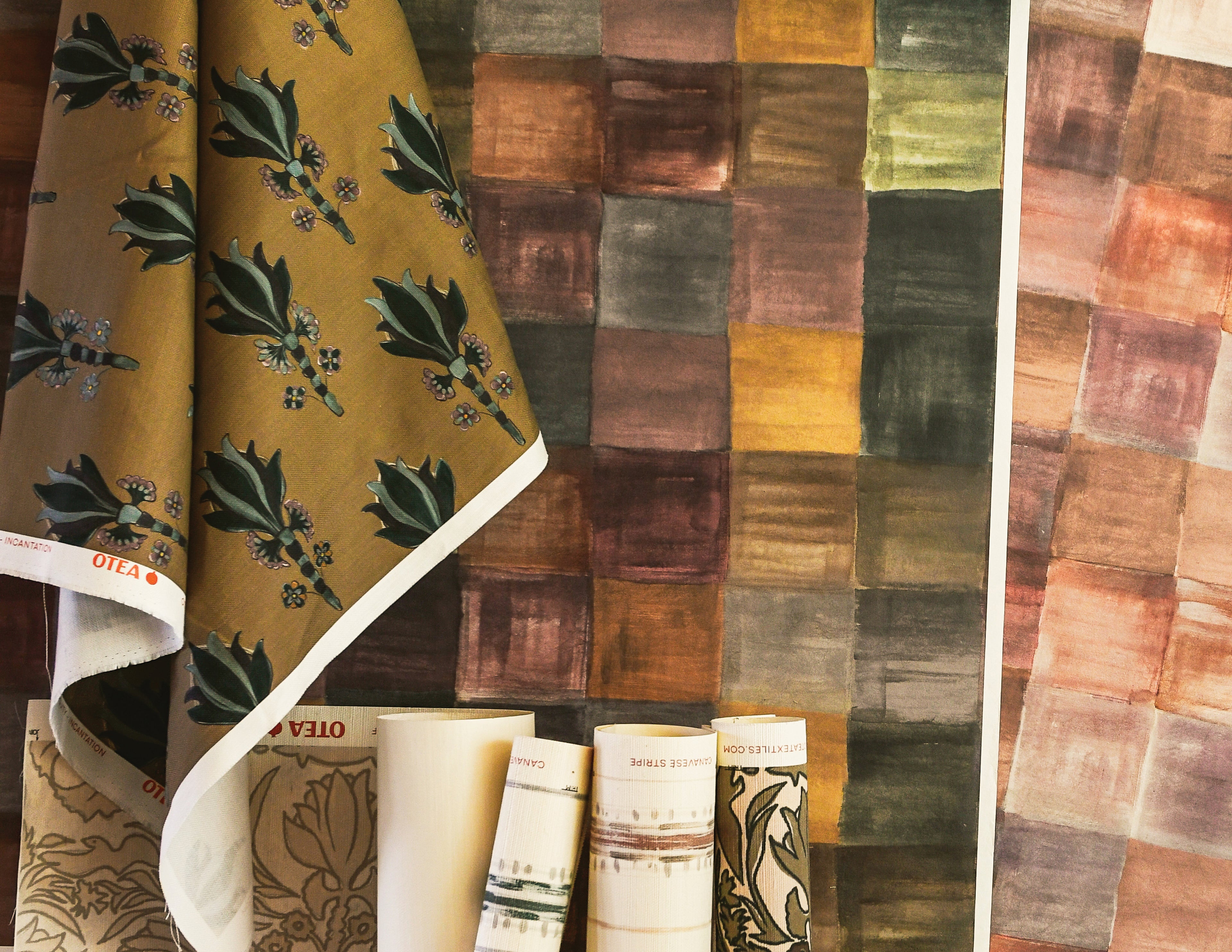 Textile with floral pattern and a patchwork of multicolored squares.