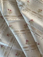 A fabric with a floral pattern featuring Silent Swan birds and a background of stripes and dots.