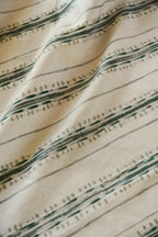 Close-up view of a linen fabric with a striped pattern featuring green and brown tones.