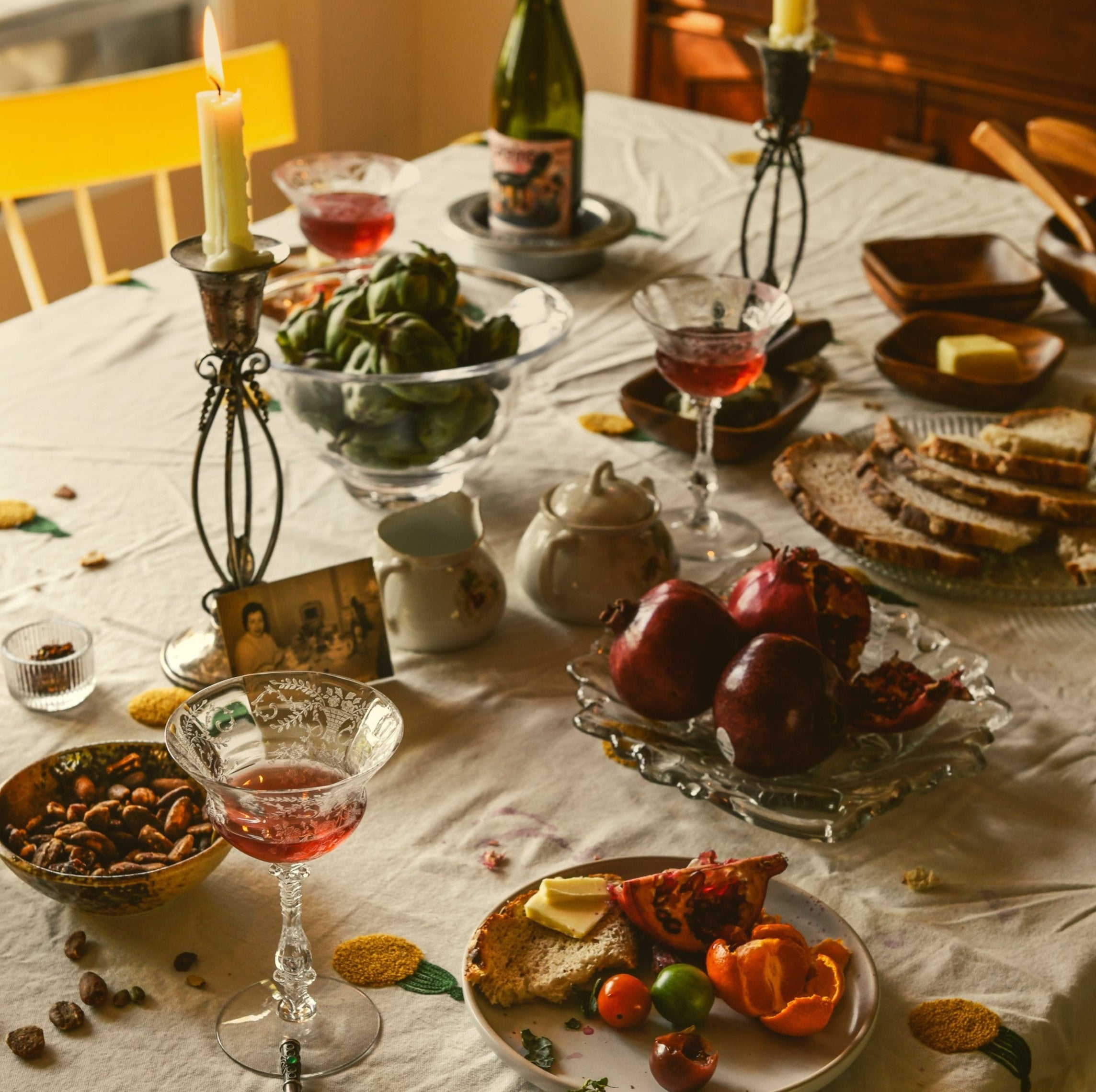 Dining table set with food, drinks, and decorative elements on a white tablecloth.