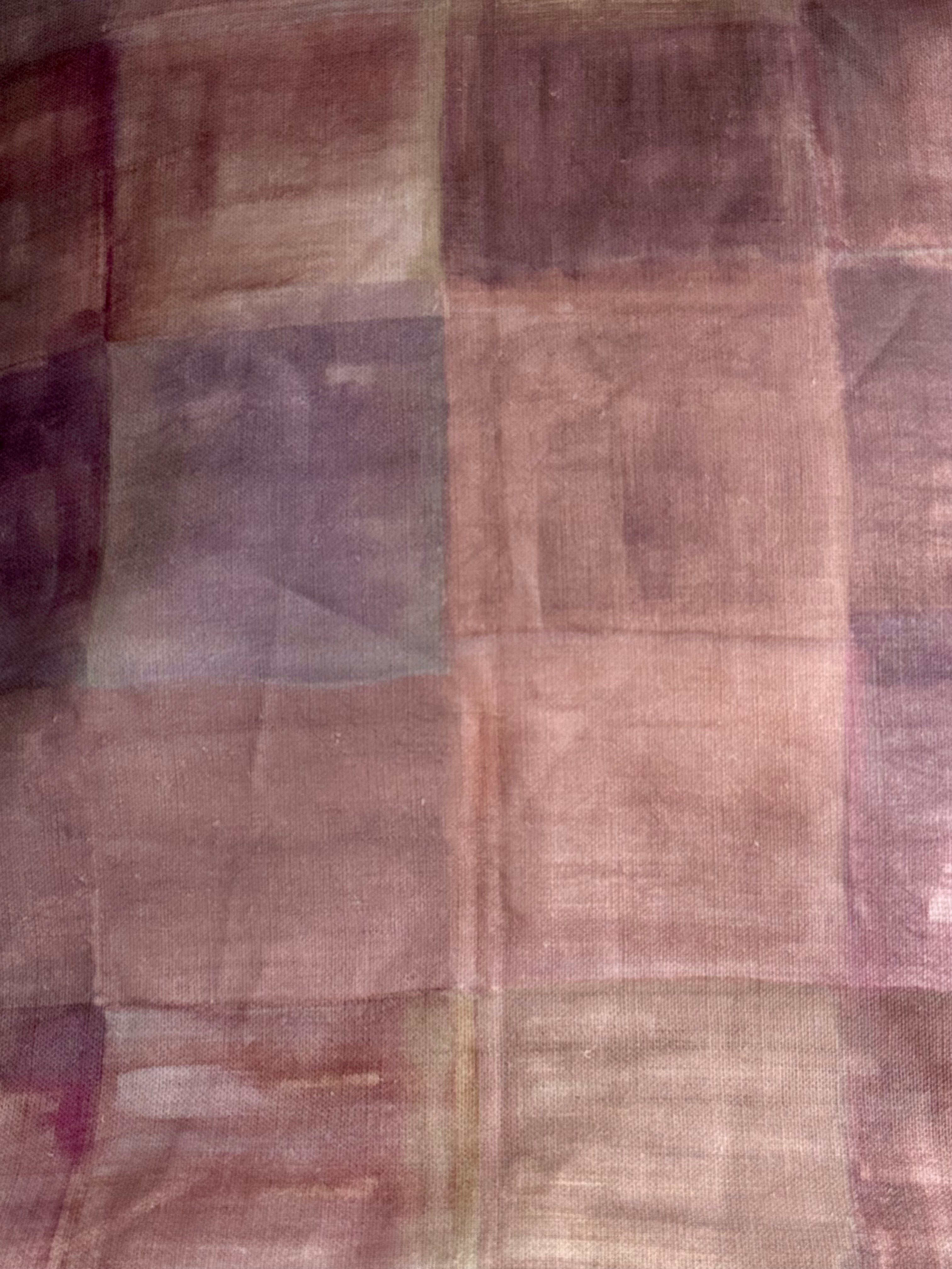 A swatch of plaid fabric with pink and brown colors, displaying the texture and pattern.