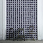 A wallpaper featuring a geometric pattern with floral-like designs in shades of blue on a light background.