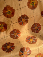 A piece of fabric with a floral pattern in brown and white colors.