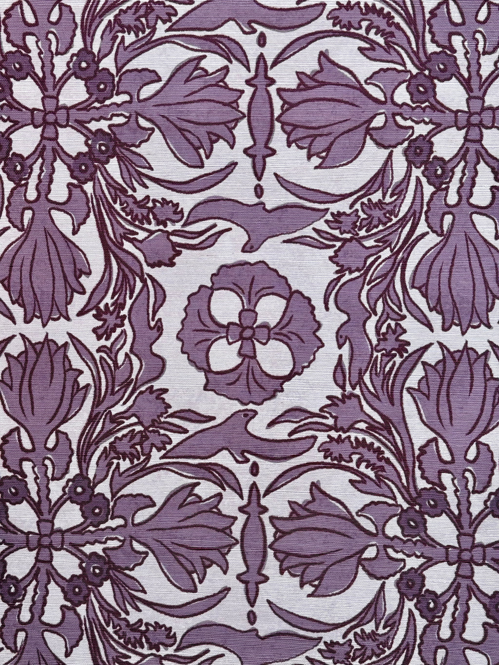 A close-up view of a wallpaper with a floral and geometric pattern in a purple hue on a light background.